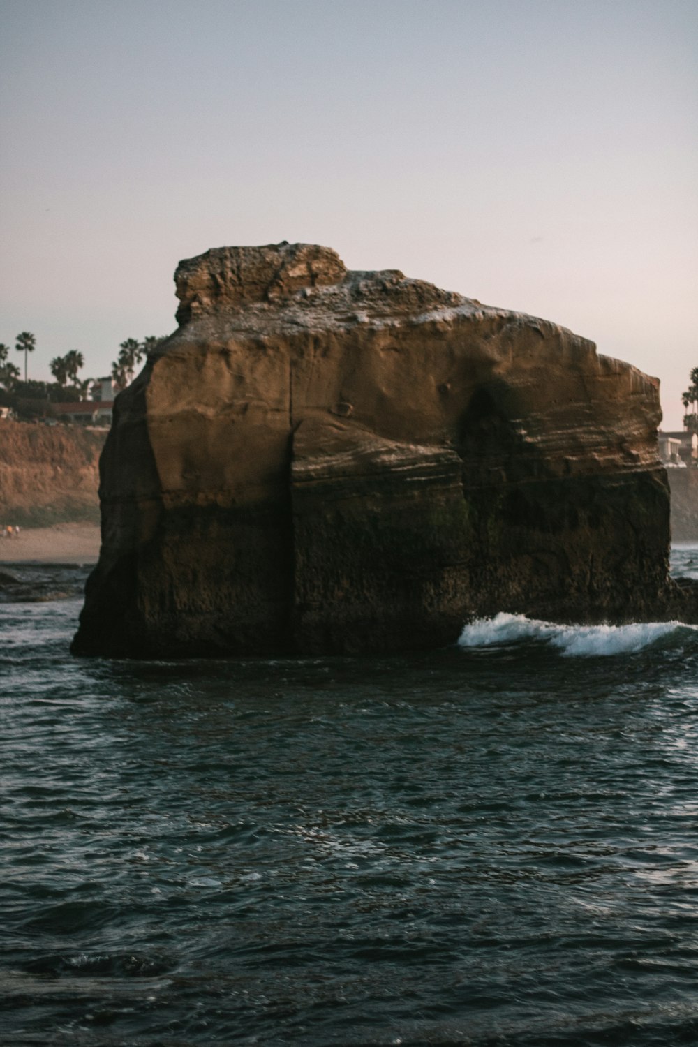 a large rock sitting in the middle of a body of water