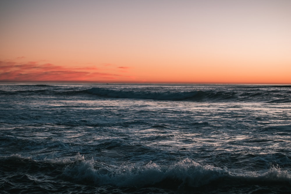 a sunset over a body of water with waves