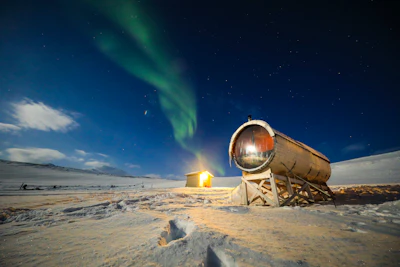 The aurora over an observatory on the snow — Svalbard, Norway
