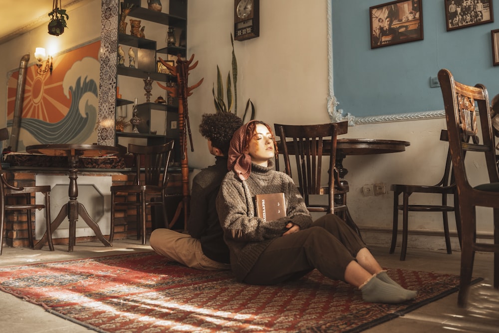 a woman sitting on a rug in a room