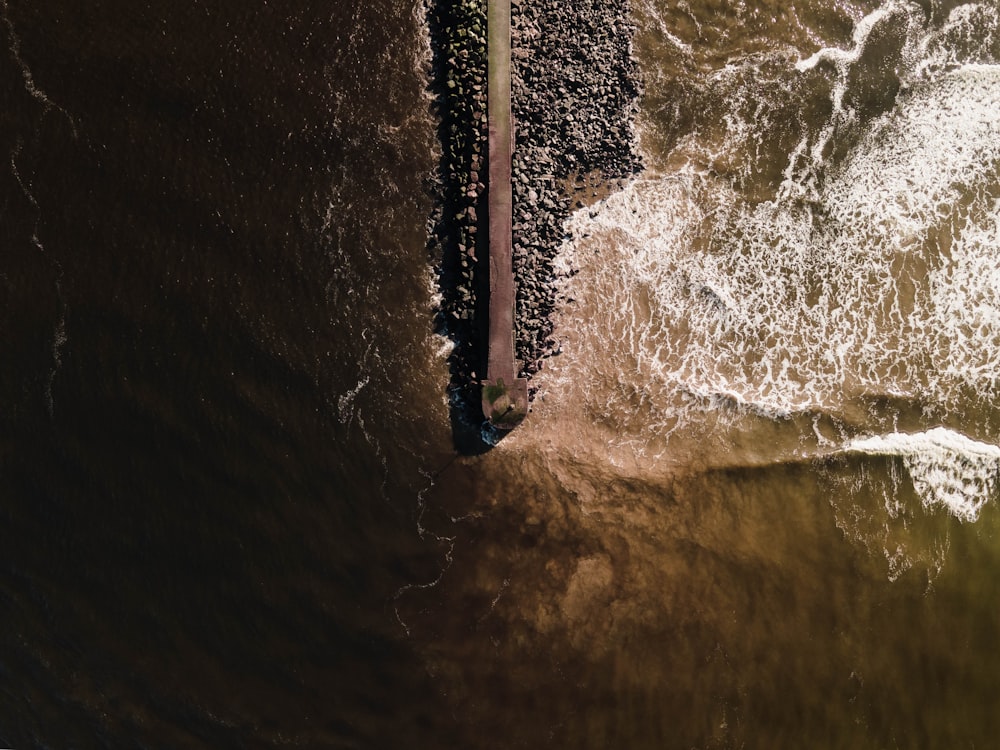 an aerial view of a pier in the ocean