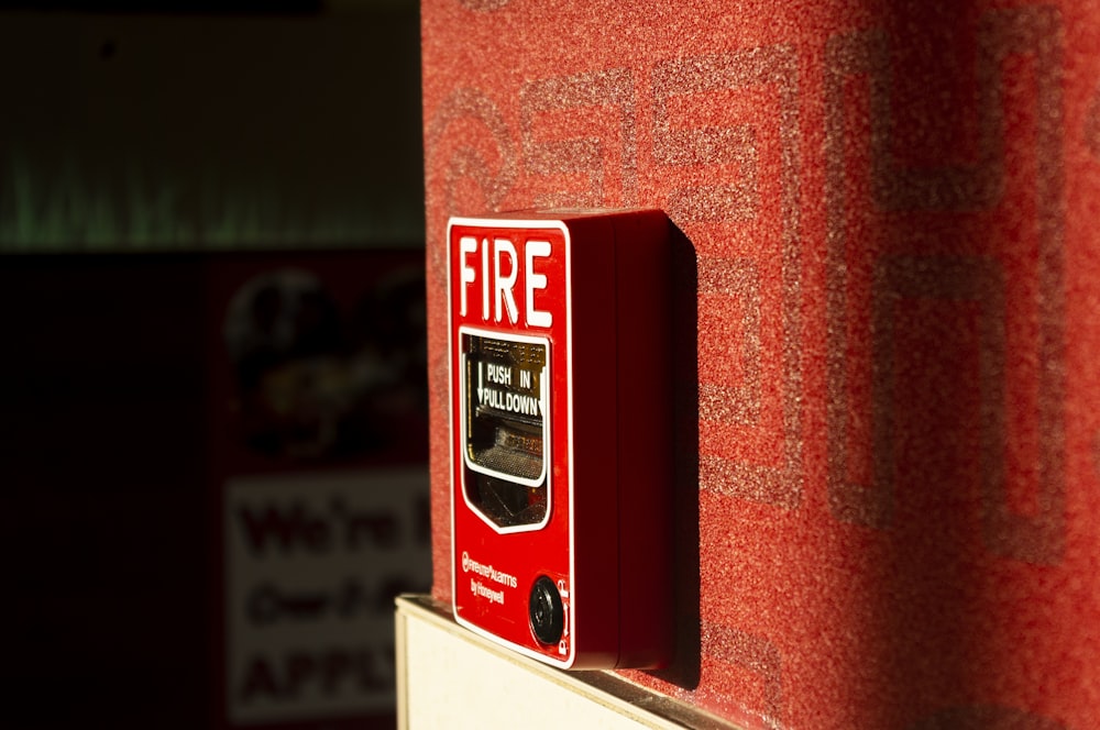 a red fire extinguisher on a red wall