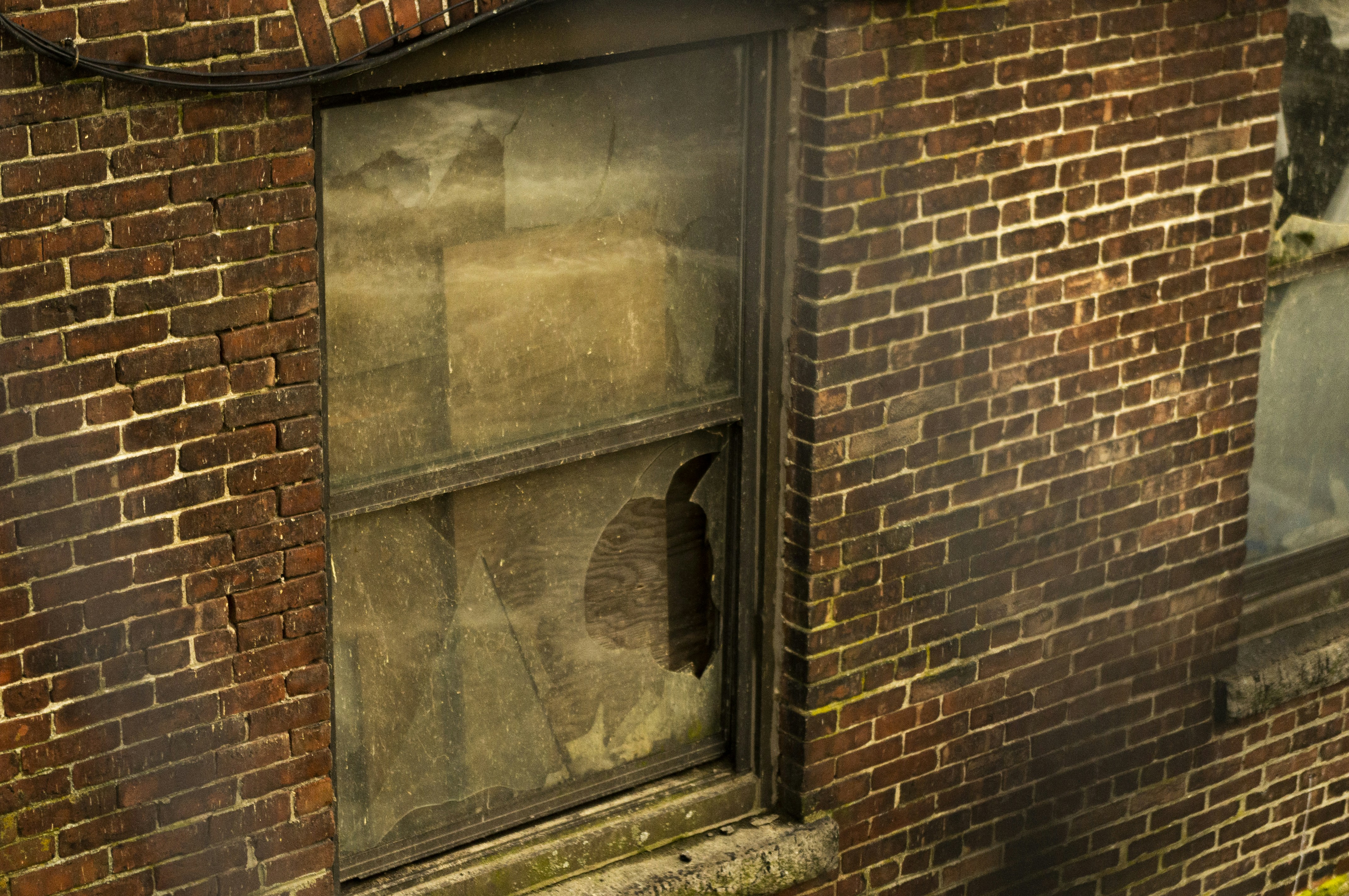 an old brick building with a broken window