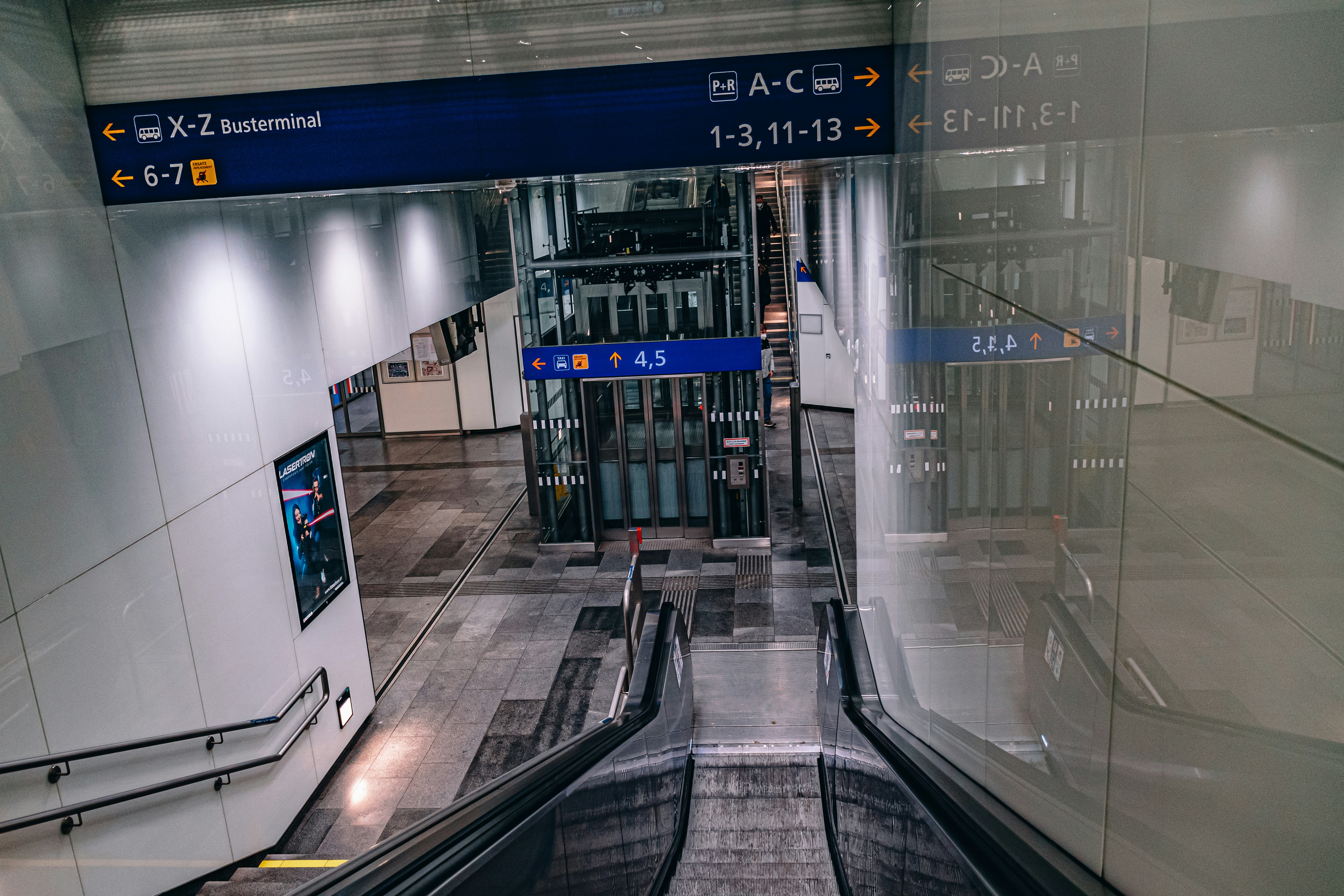 an escalator in a building with a sign above it