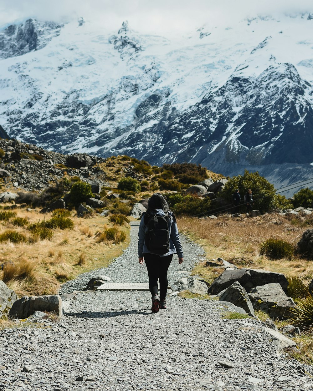 a person with a backpack walking up a trail