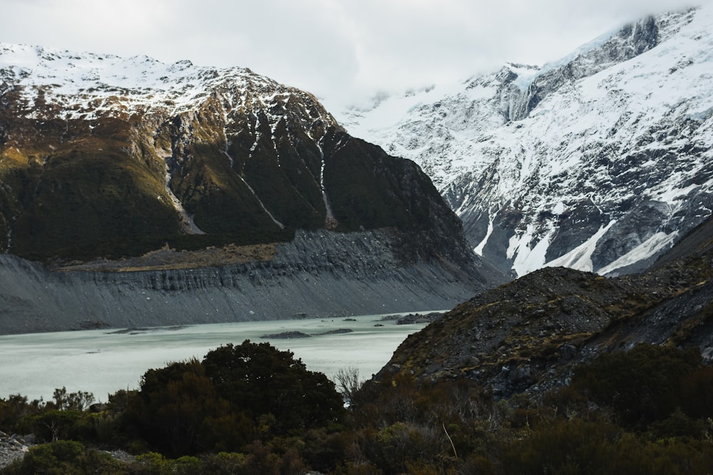 Una cordillera nevada con un lago en primer plano