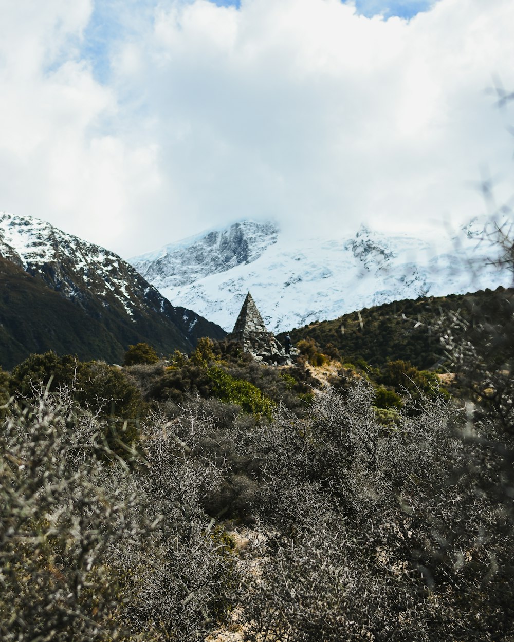 a mountain with a snow covered mountain in the background