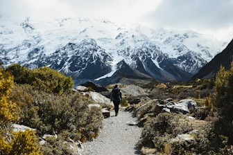 a man hiking up a trail in the mountains