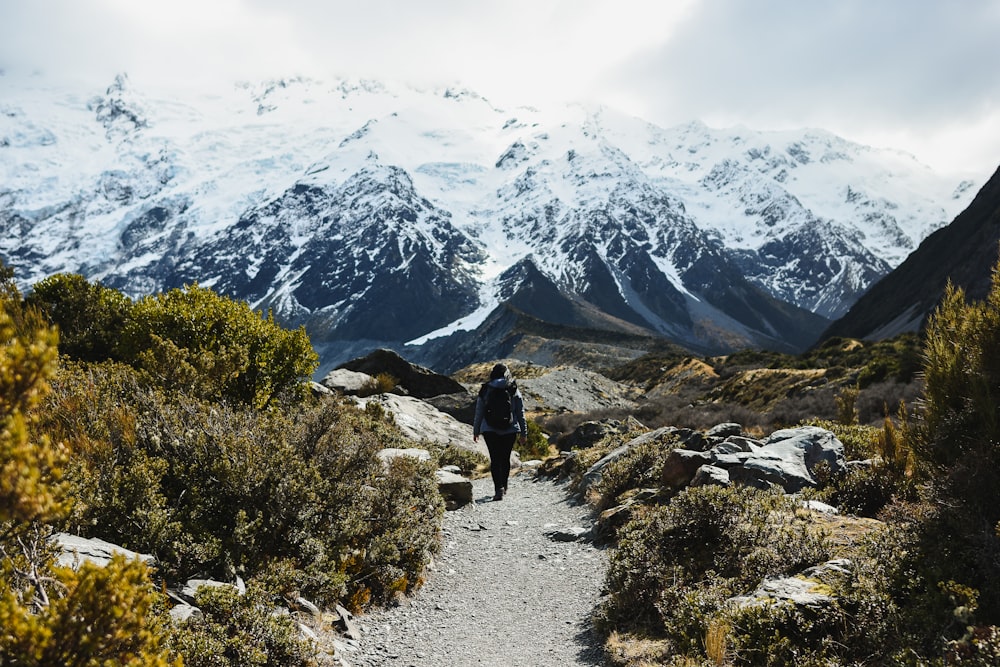 a man hiking up a trail in the mountains