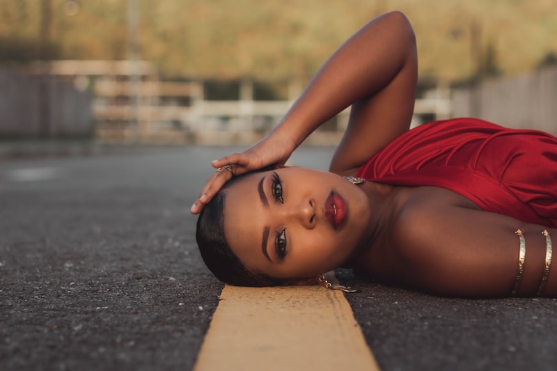 a woman in a red dress laying on the ground