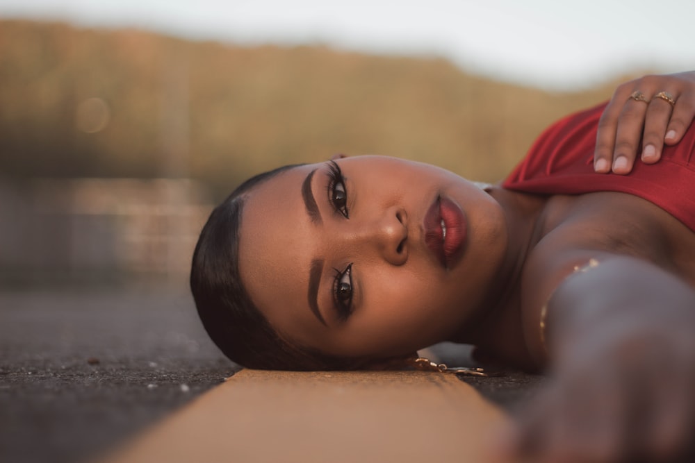 a woman in a red dress laying on the ground