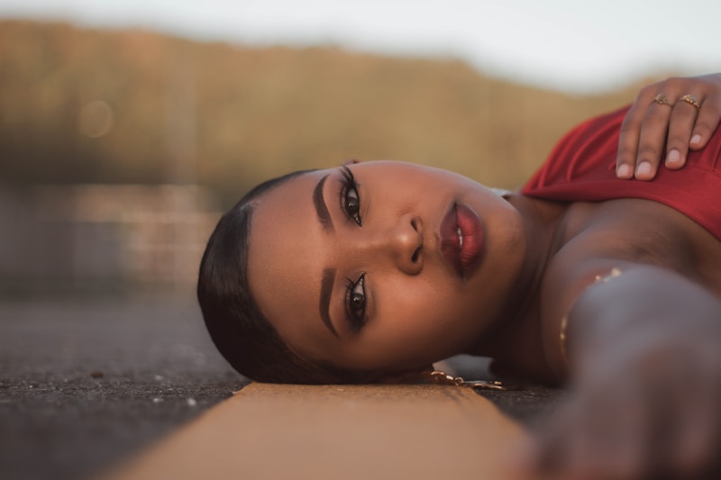 a woman in a red dress laying on the ground
