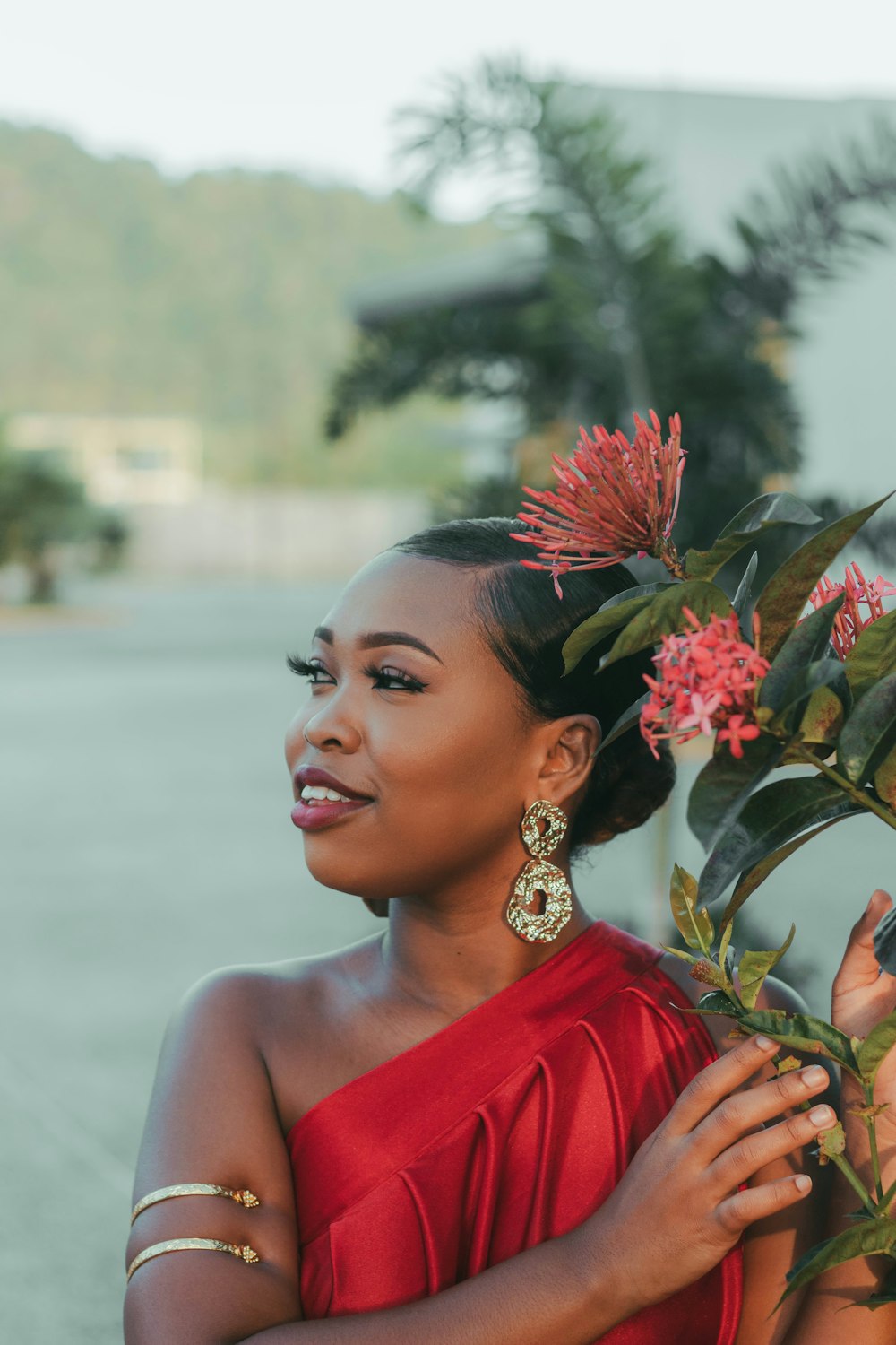 a woman in a red dress holding a flower