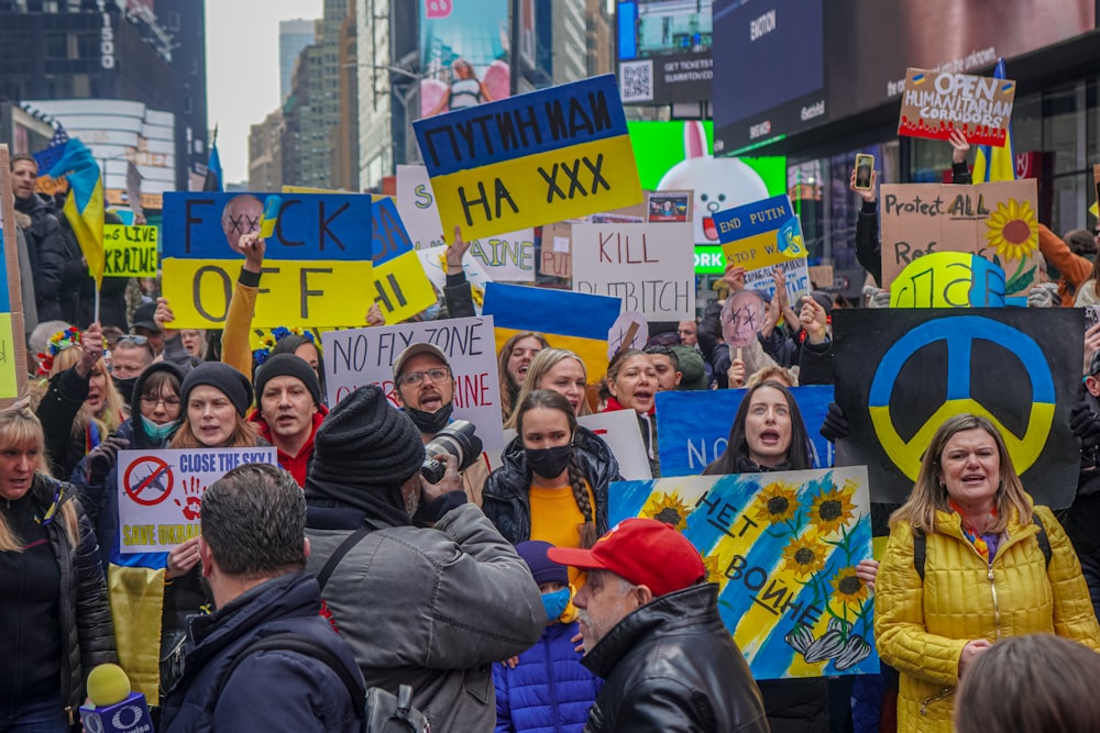 a large group of people holding signs in the street