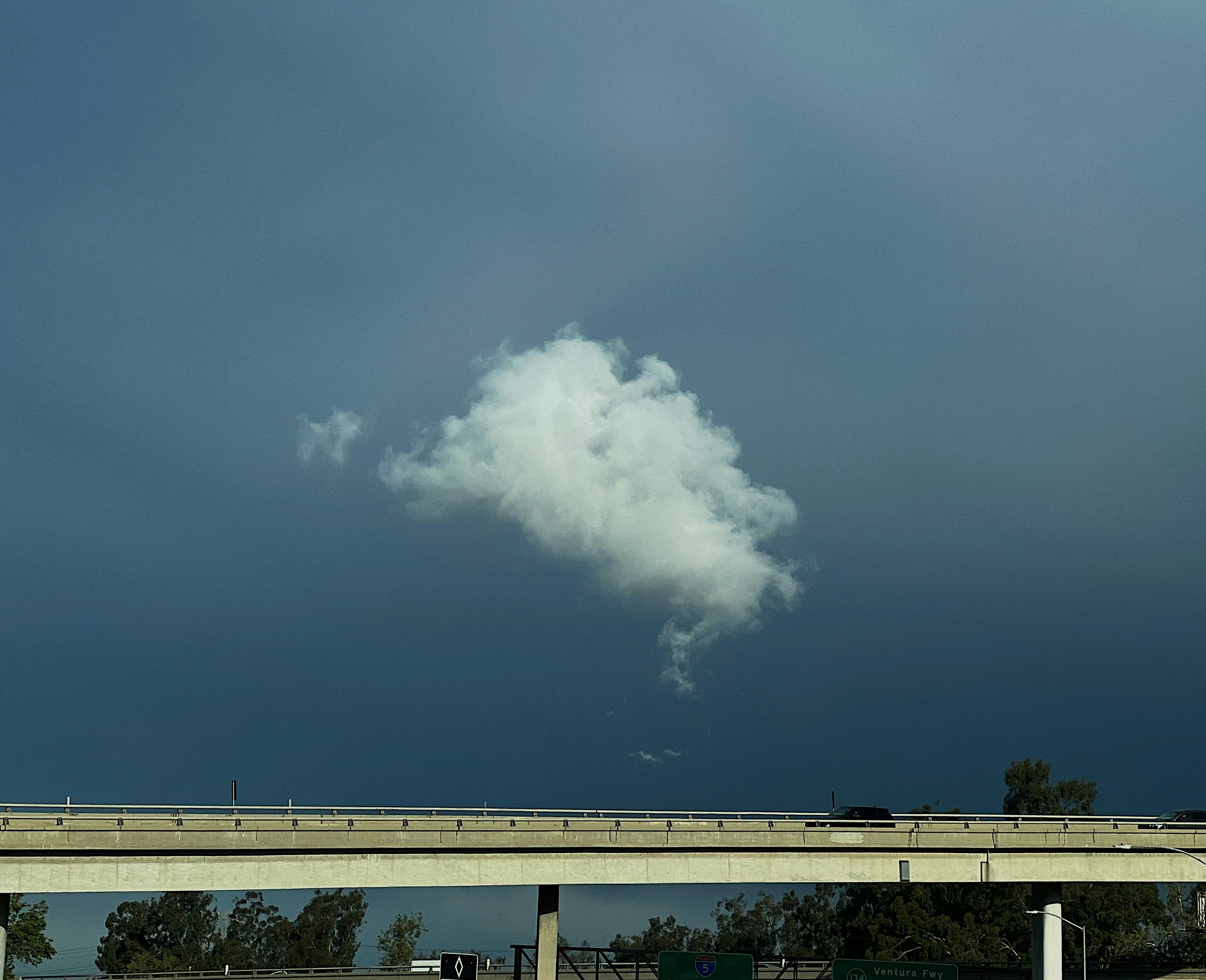 Una nuvola fluttua su un'autostrada sotto un cielo nuvoloso