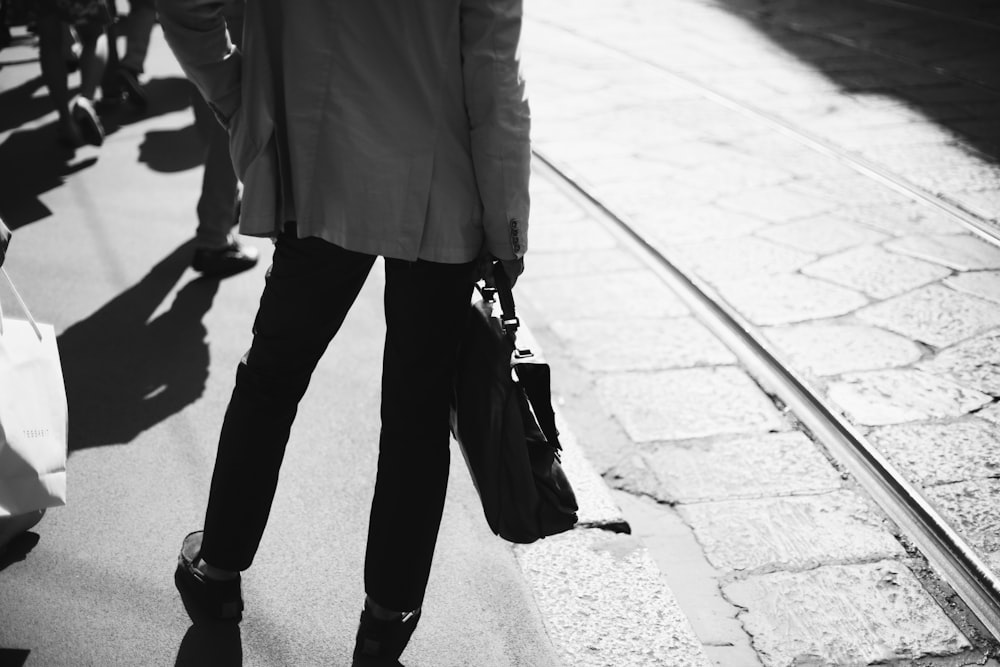 a person walking down a street with a handbag