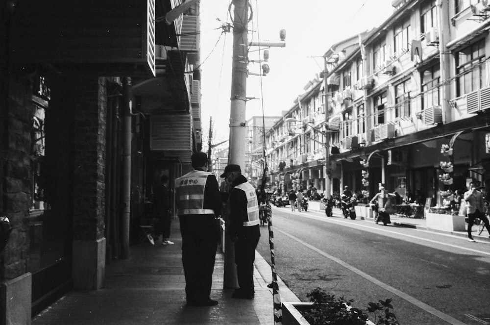 a couple of people that are standing on a sidewalk