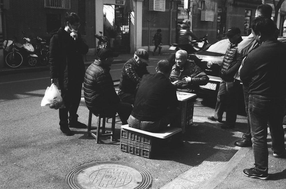 a black and white photo of people sitting on benches