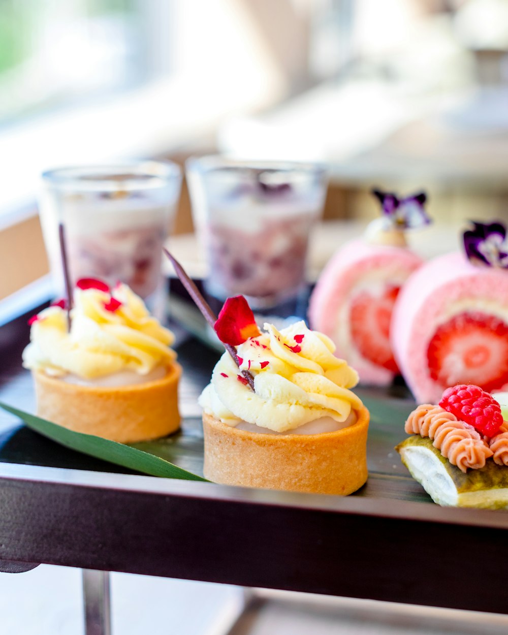 three desserts are arranged on a tray on a table