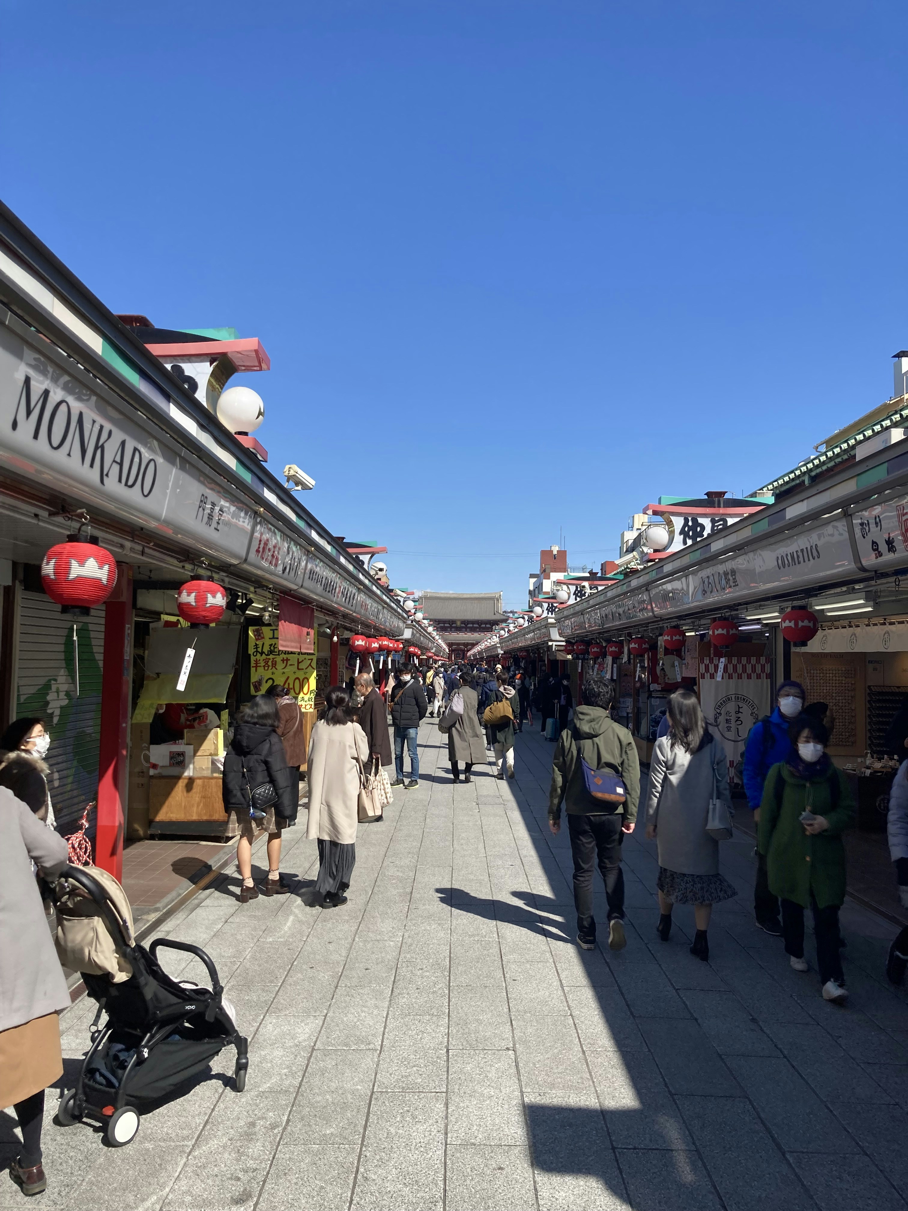 a group of people walking down a street next to shops