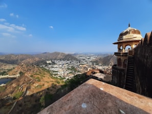 A panoramic view of Jaipur's forts and palaces under a clear blue sky.