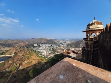 A panoramic view of Jaipur's forts and palaces under a clear blue sky.