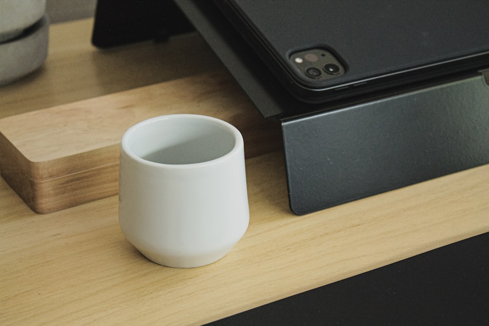 a white cup sitting on top of a wooden table