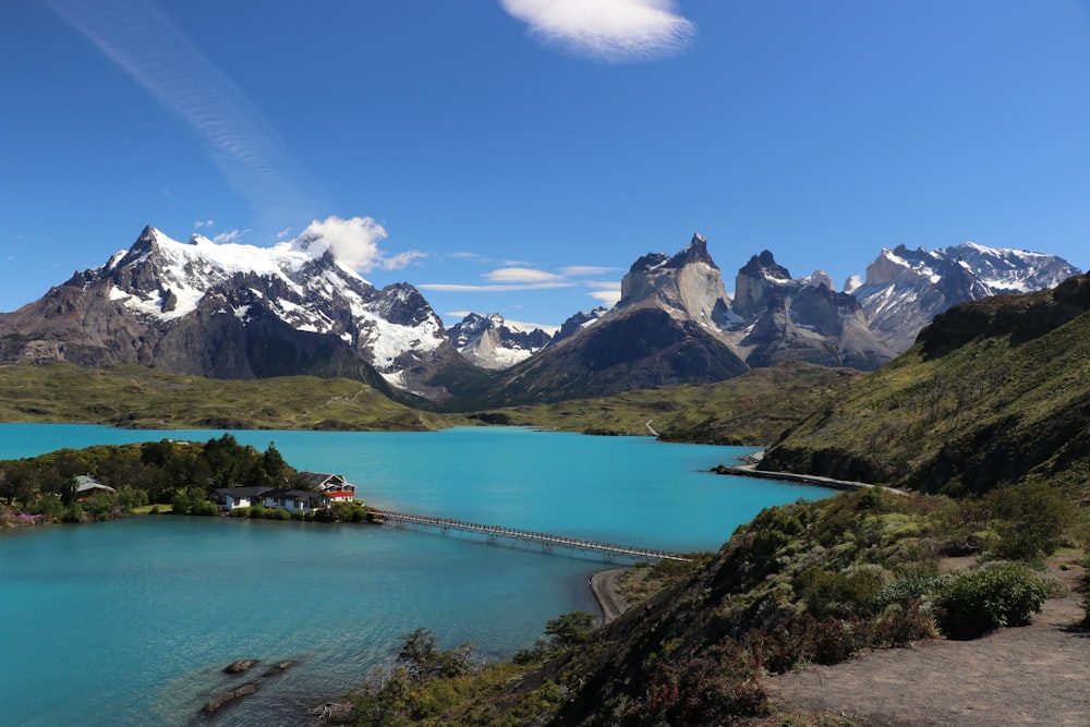 a lake surrounded by mountains and a bridge