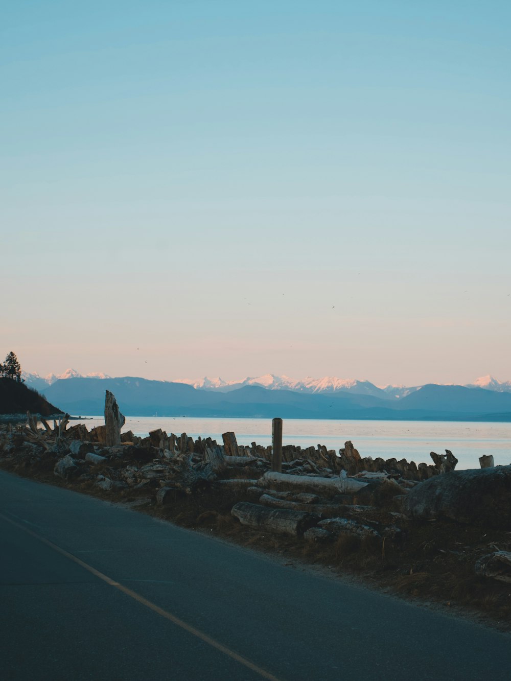 a person standing on the side of a road next to a body of water