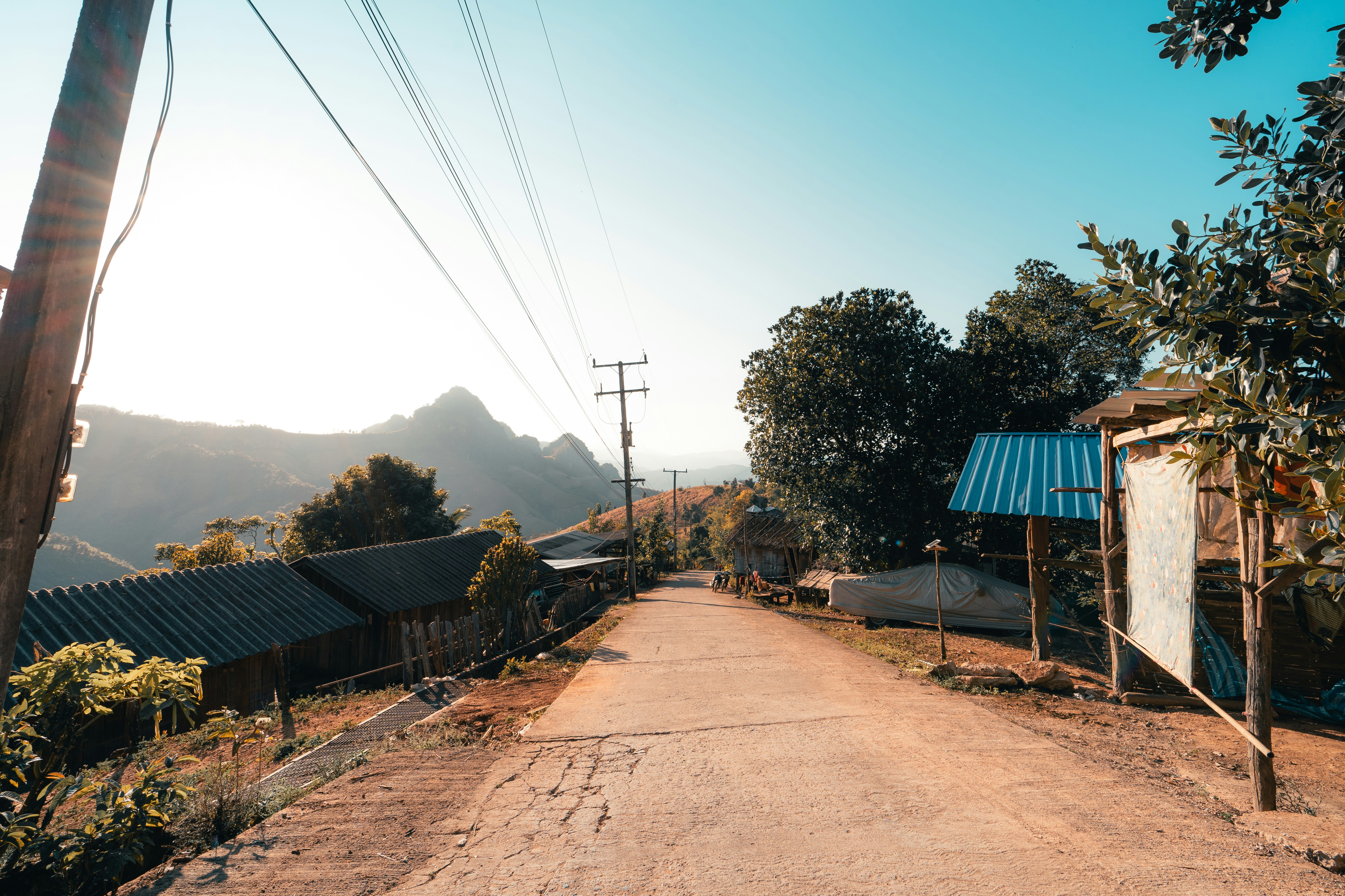 uma estrada de terra cercada por árvores e montanhas