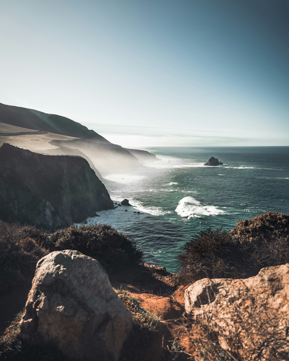 a view of the ocean from the top of a hill