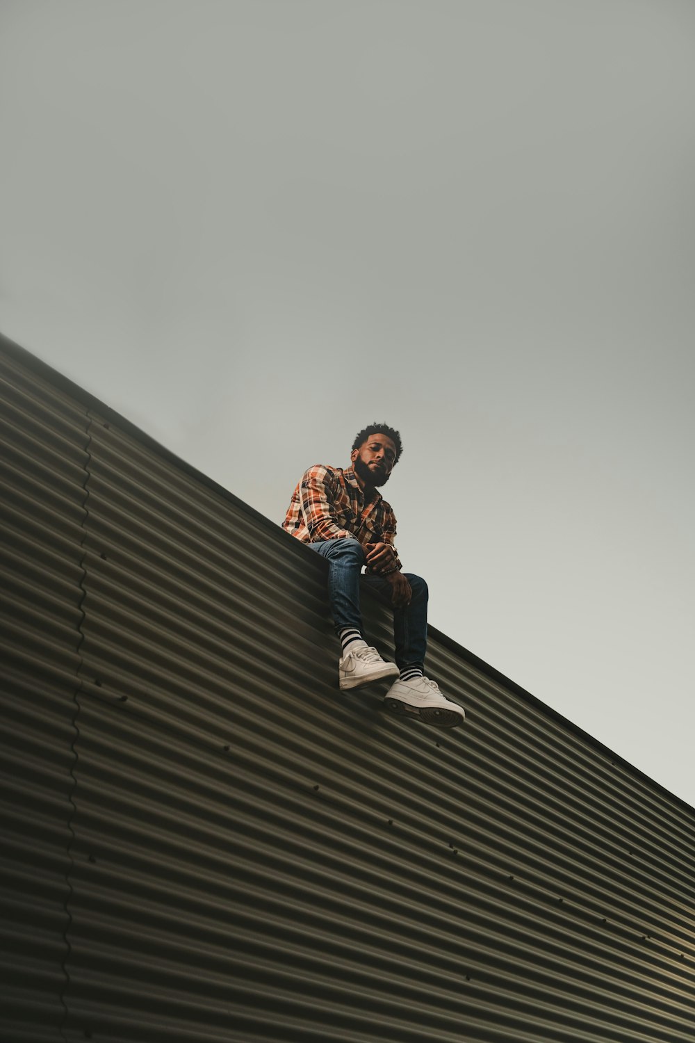 a man sitting on top of a metal roof