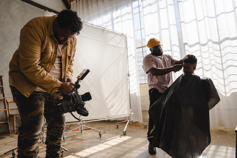 a man getting his hair cut by another man