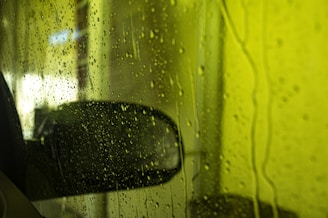 a car's side view mirror on a rainy day