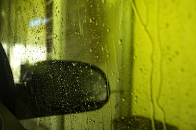 a car's side view mirror on a rainy day