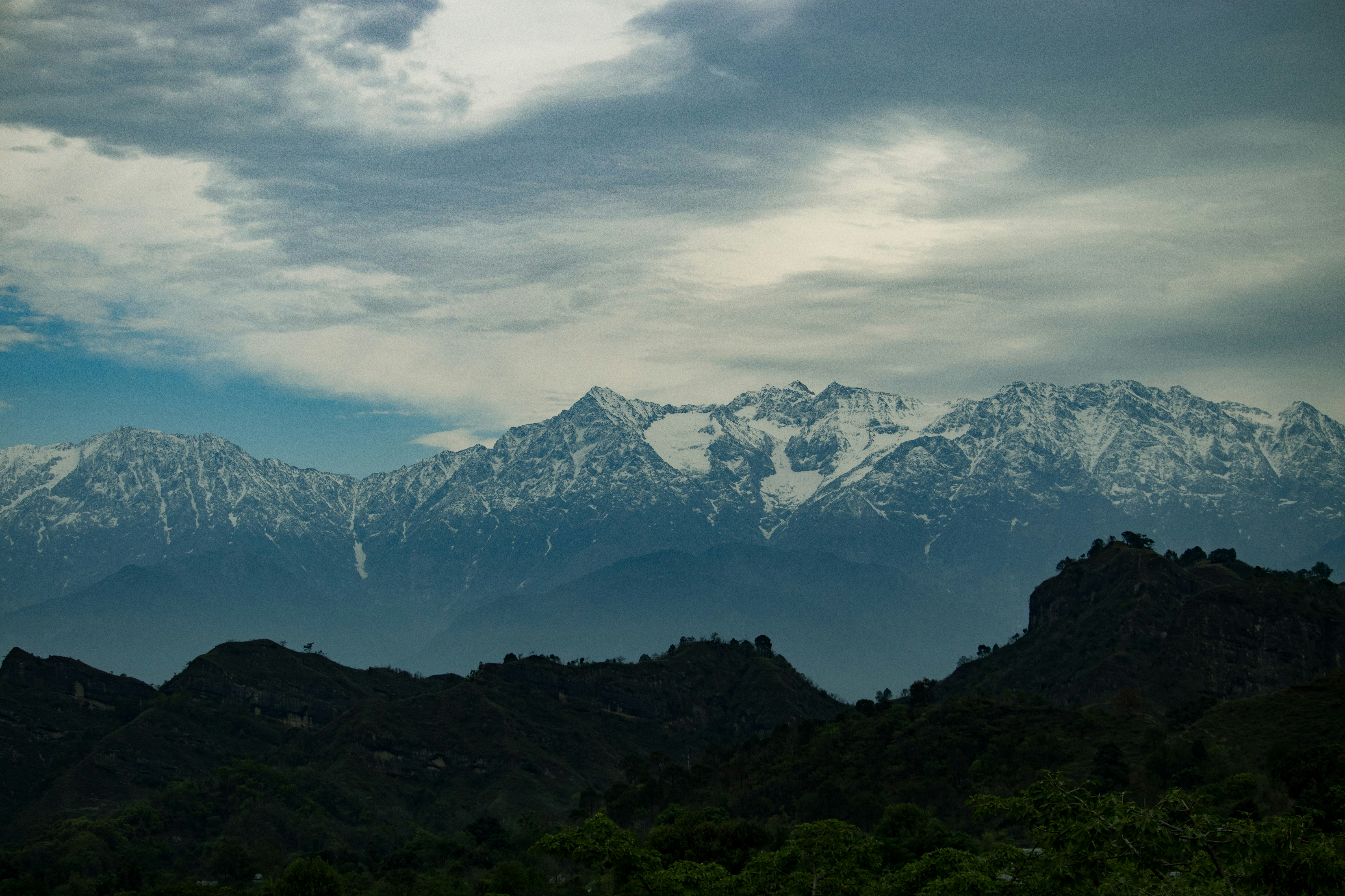 a mountain range with snow capped mountains in the distance