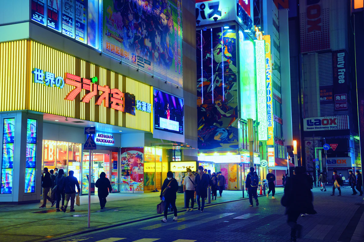 Akihabara at night, neon billboards in kanji above a busy crosswalk