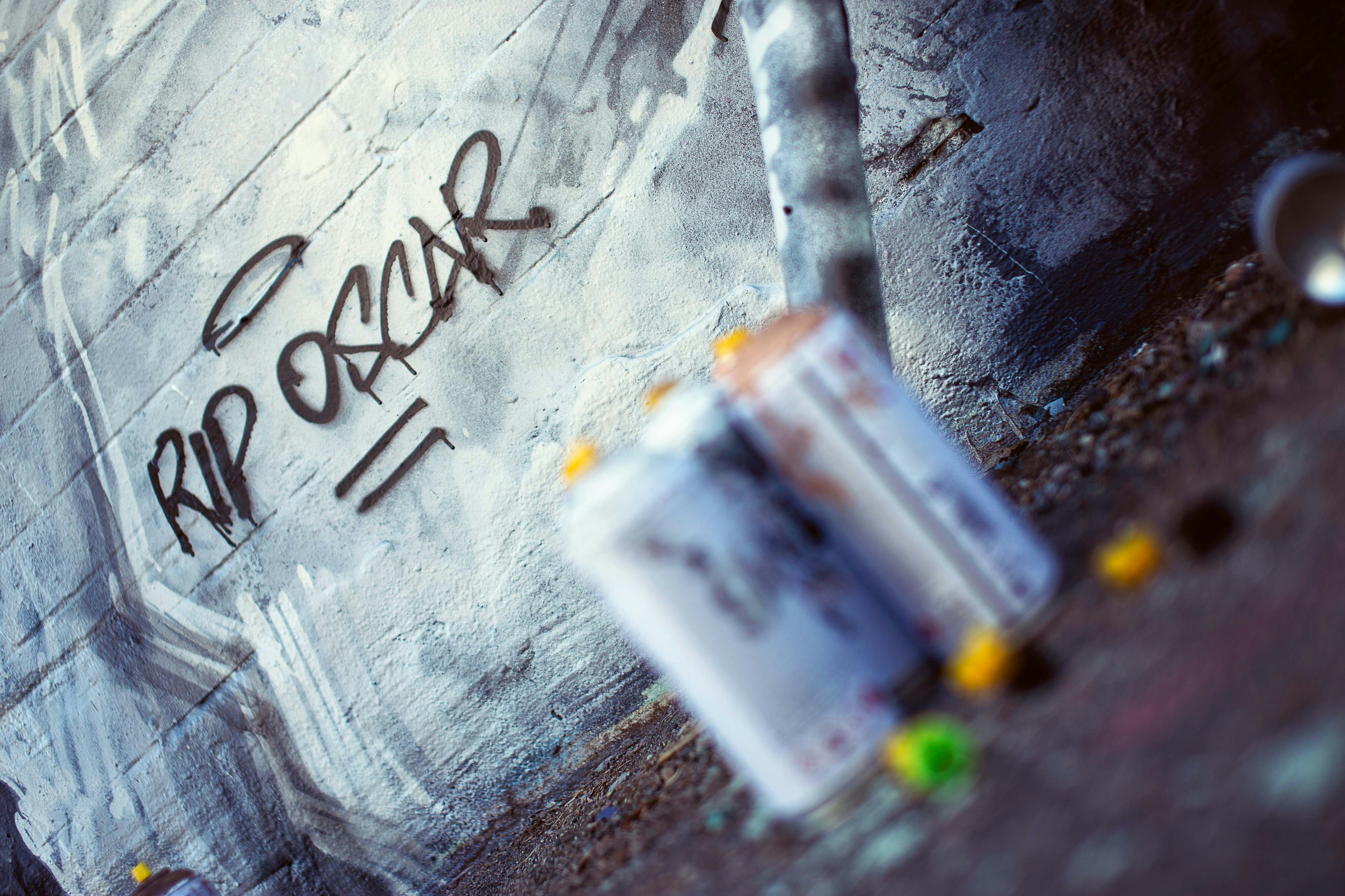 una pared cubierta de graffiti con un parquímetro delante