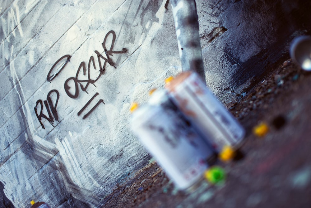 a graffiti covered wall with a parking meter in front of it