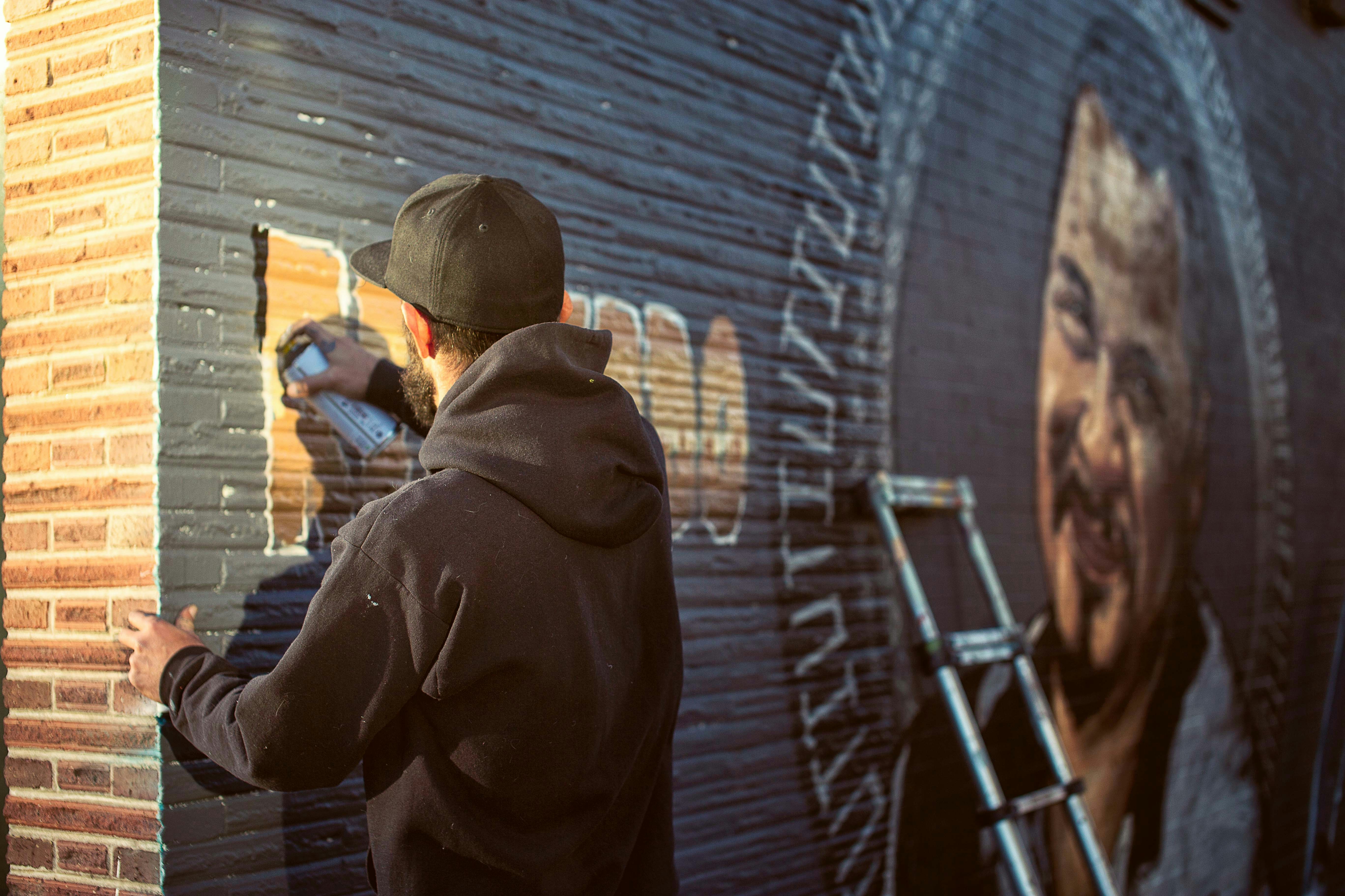 a man painting a mural on the side of a building