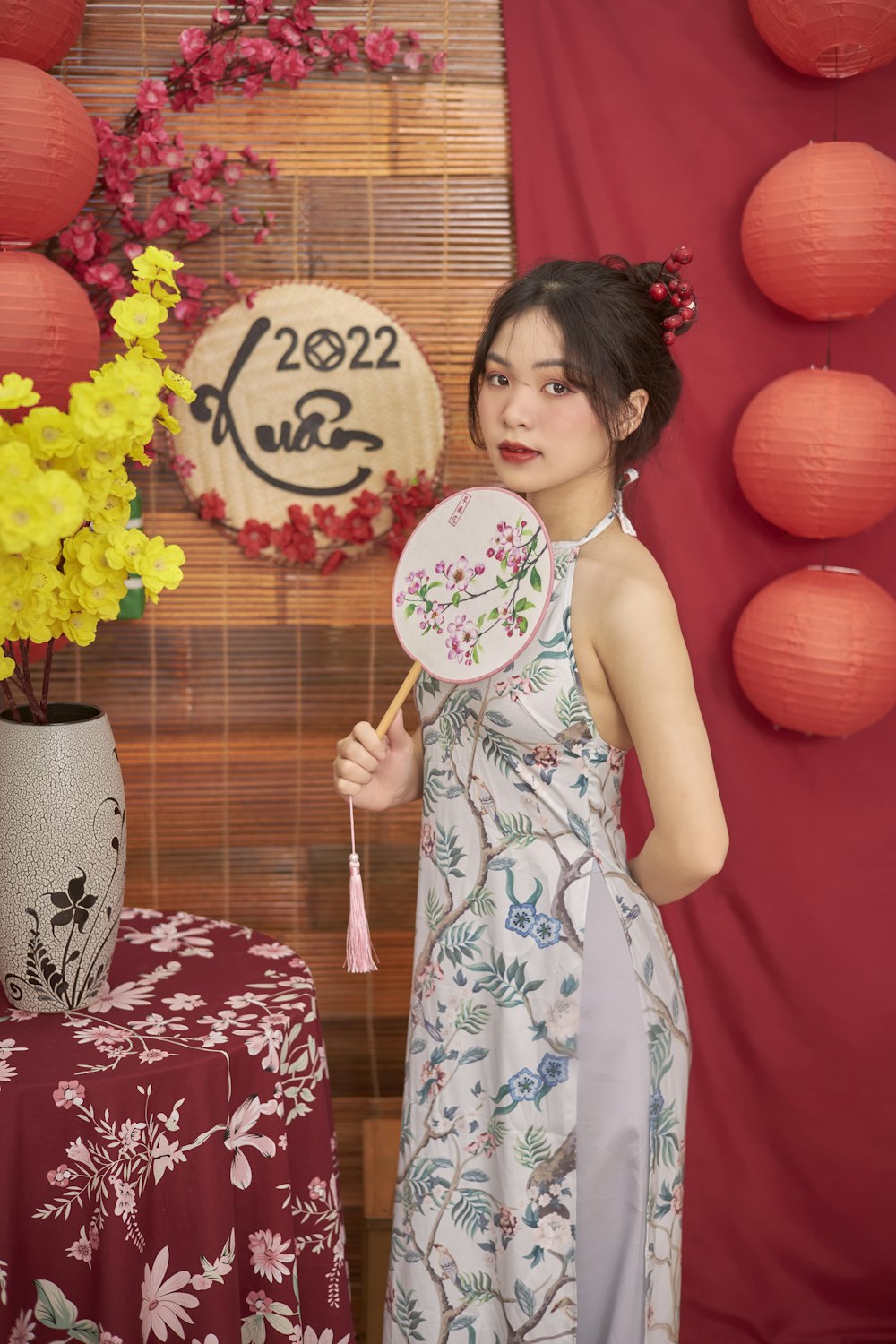 a woman in a dress holding a fan