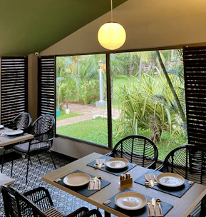 a dining room with a view of a garden