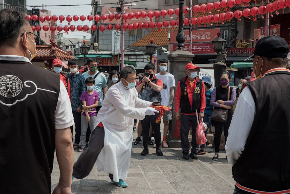 a man in a white robe is dancing on the street