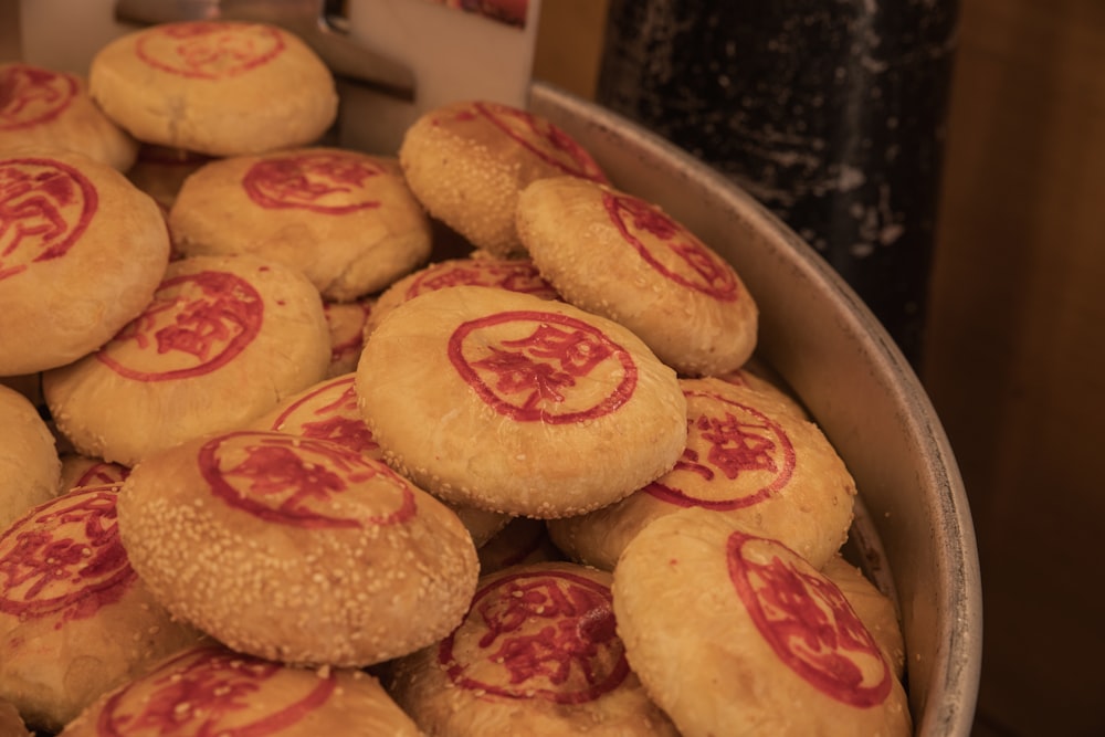a bowl full of cookies with red designs on them