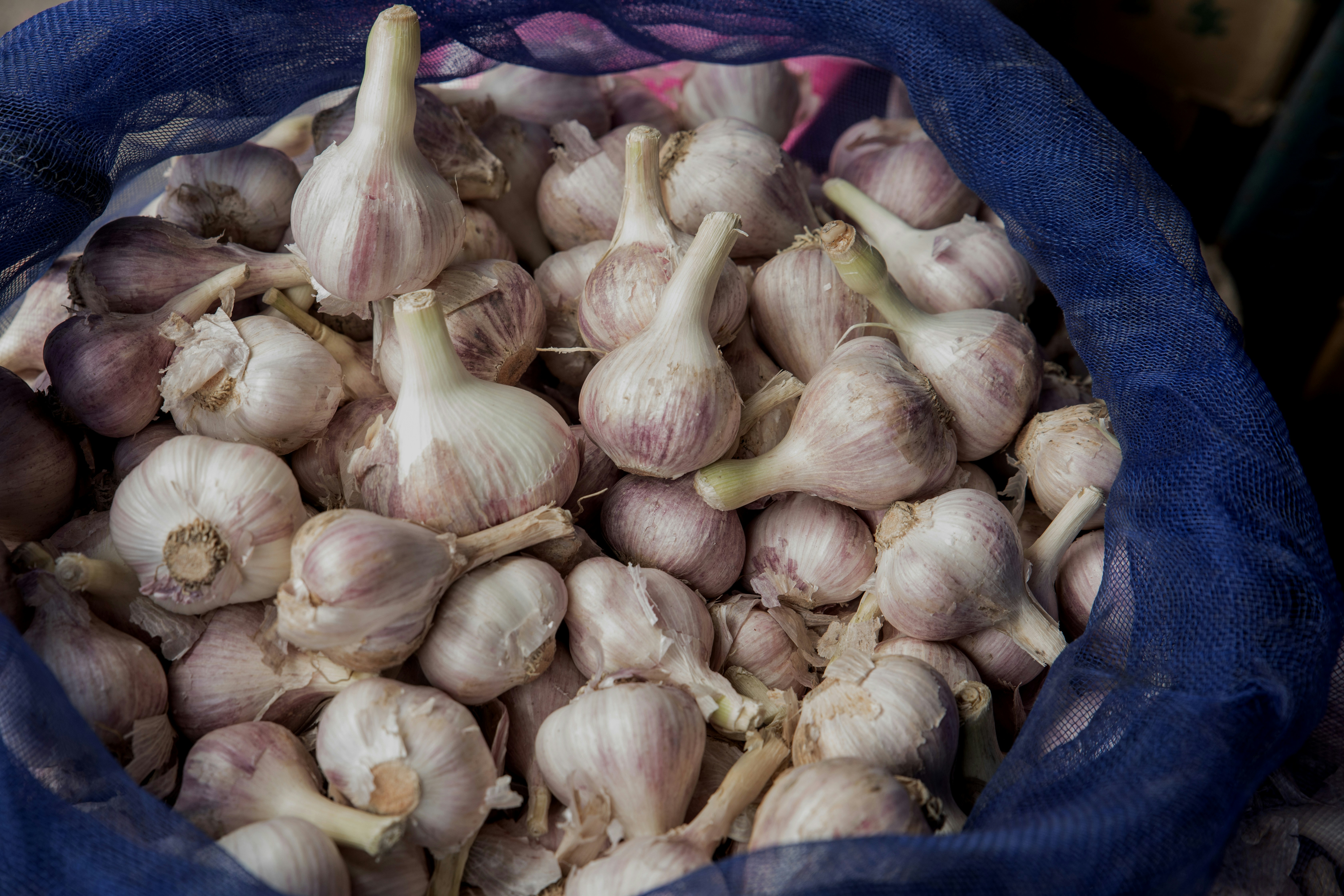 a blue bag filled with garlic on top of a table