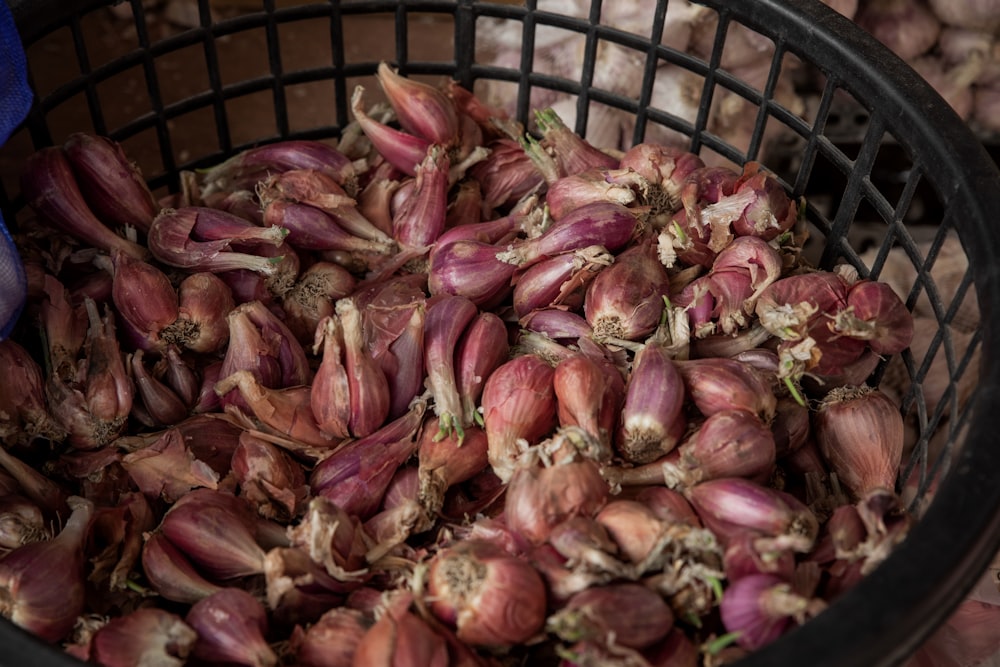 a basket filled with lots of garlic sitting on top of a table