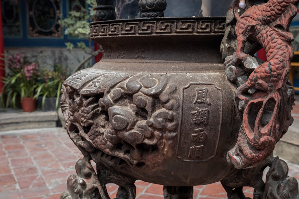 a large vase sitting on top of a brick sidewalk