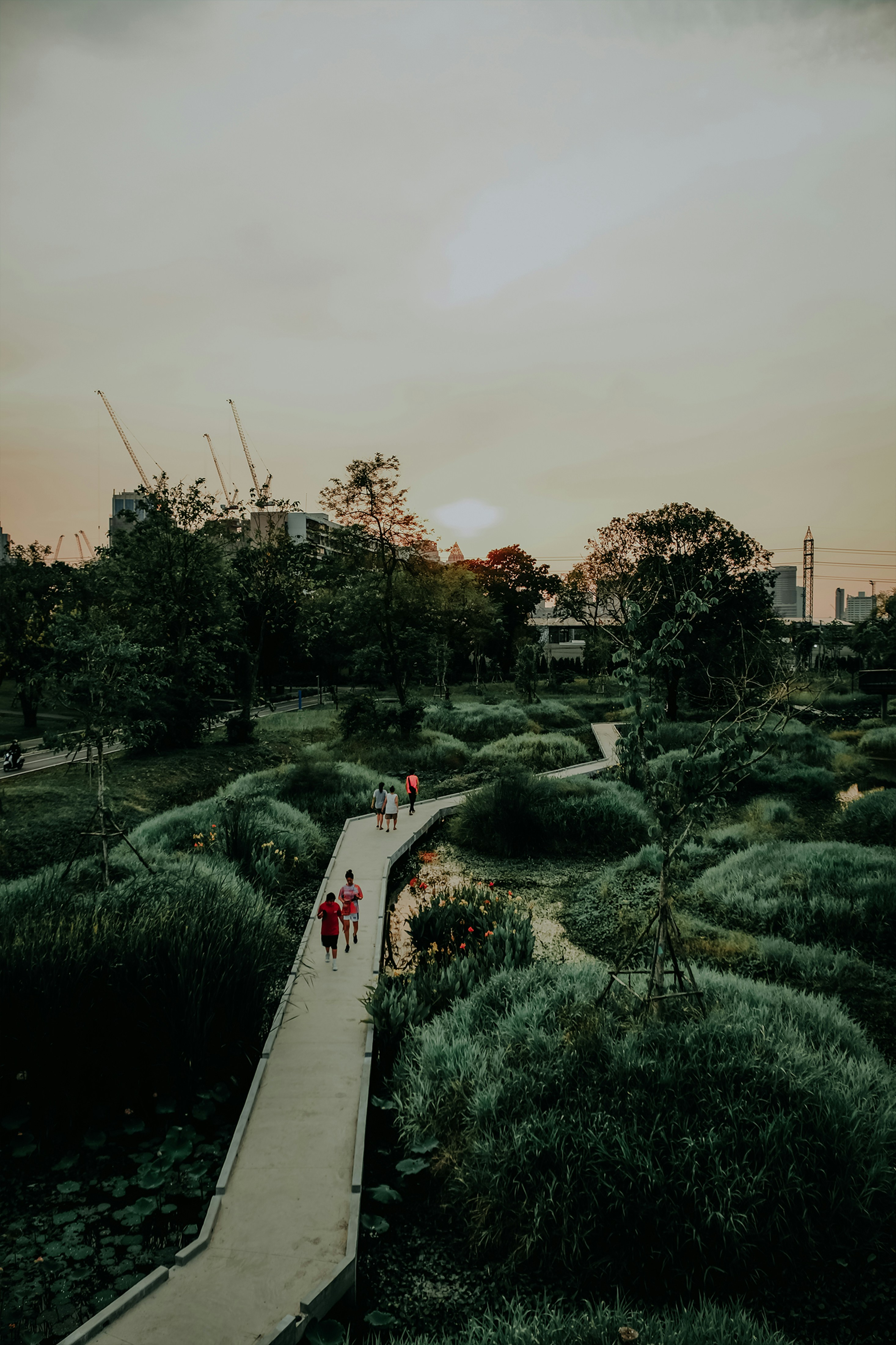 a couple of people walking down a wooden walkway