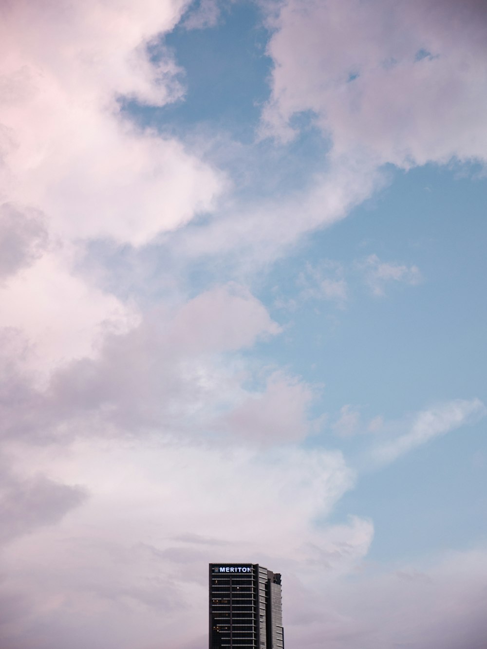 a very tall building sitting under a cloudy sky