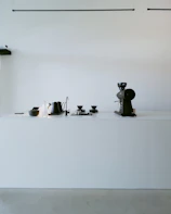 A sleek coffee maker on a minimalist kitchen counter with natural light.